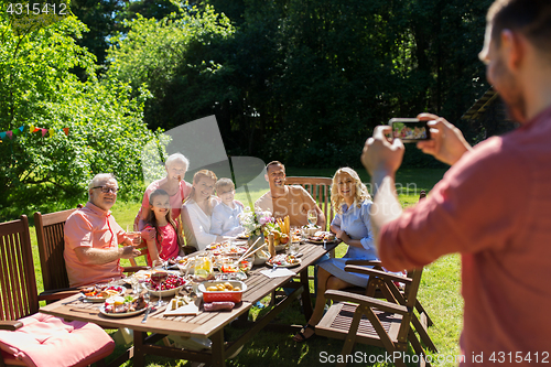 Image of happy family photographing by smartphone in summer