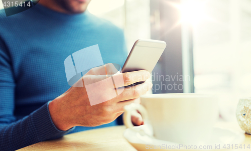Image of close up of man with smartphones at cafe