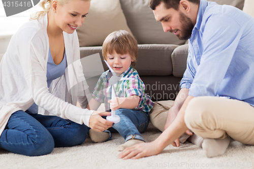 Image of happy family playing with toy wind turbine