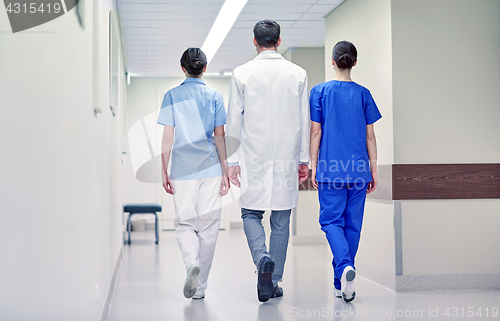 Image of group of medics or doctors walking along hospital