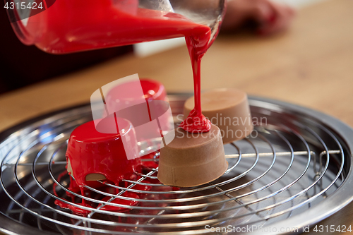 Image of jug pouring glaze to cakes at pastry shop