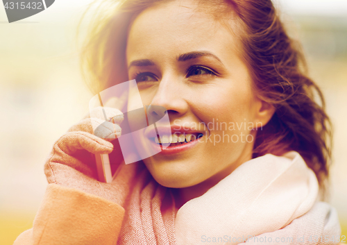 Image of woman calling on smartphone in autumn park