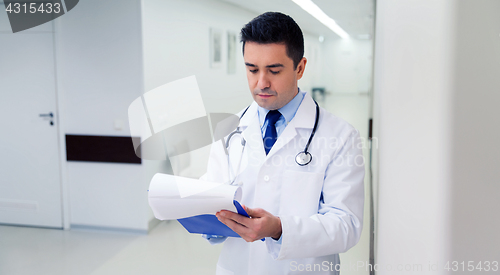 Image of doctor writing to clipboard at hospital
