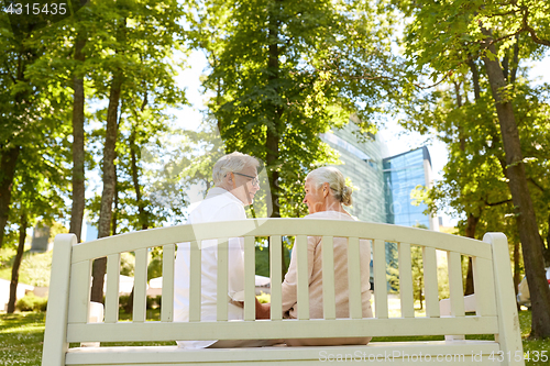 Image of happy senior couple sitting on bench at park