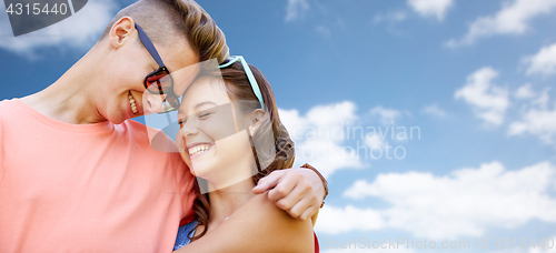 Image of happy teenage couple hugging over blue sky