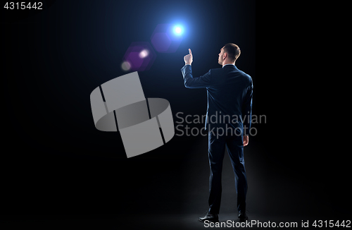 Image of businessman in suit pointing finger to lens flare