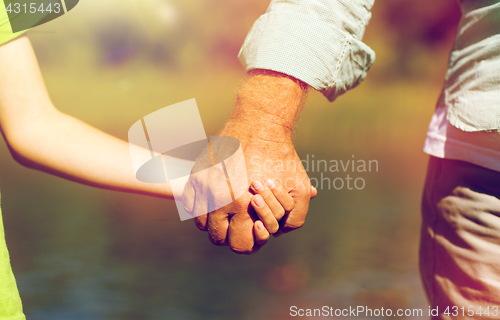 Image of senior man and child holding hands