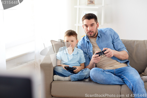 Image of father and son playing video game at home