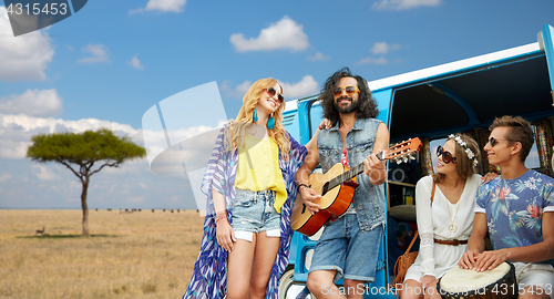 Image of hippie friends playing music at minivan in africa