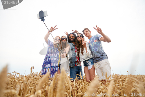 Image of hippie friends with smartphone on selfie stick