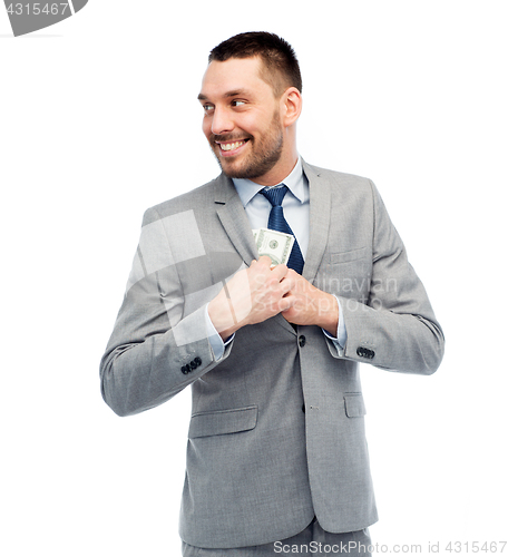 Image of businessman hiding money into jacket pocket