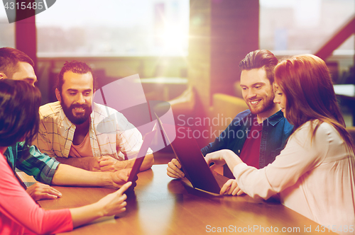 Image of smiling friends discussing menu at restaurant