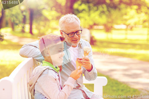 Image of old man and boy eating ice cream at summer park