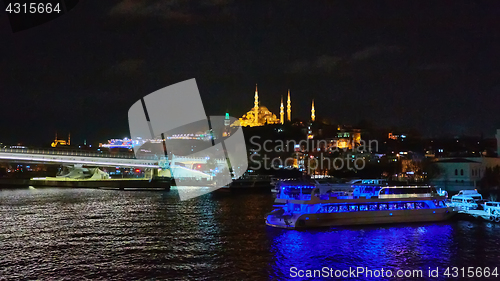 Image of Night shot of Golden Horn Metro Bridge or Halic Bridge overlapping Suleymaniye Mosque, Istanbul, Turkey
