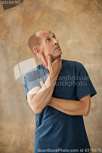 Image of Worried mature man touching his head.