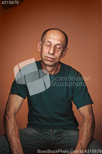 Image of Worried mature man sitting at studio