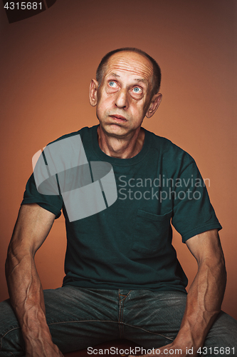 Image of Worried mature man sitting at studio