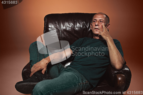 Image of Worried mature man sitting at studio