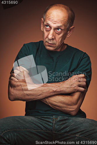 Image of Worried mature man sitting at studio