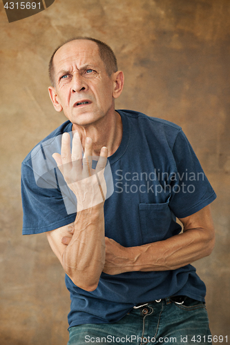 Image of Worried mature man standing at studio