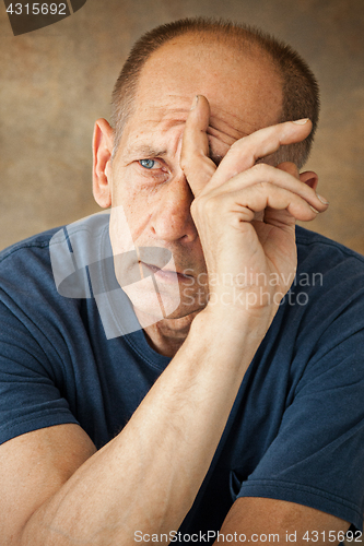 Image of Worried mature man touching his head.