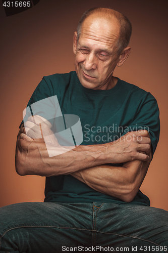 Image of Worried mature man sitting at studio