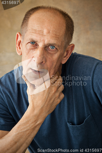 Image of Worried mature man touching his head.