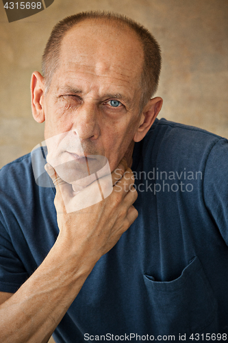 Image of Worried mature man touching his head.
