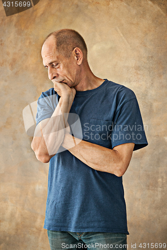 Image of Worried mature man touching his head.