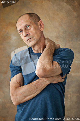 Image of Worried mature man touching his head.