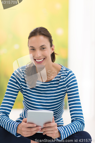 Image of young women using tablet computer on the floor