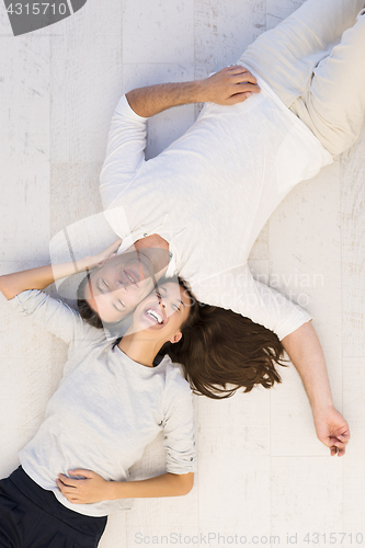 Image of handsome couple lying on floor