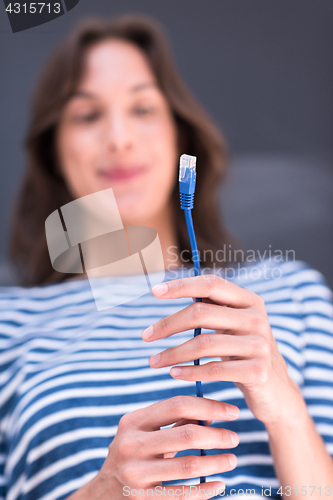 Image of woman holding a internet cable in front of chalk drawing board