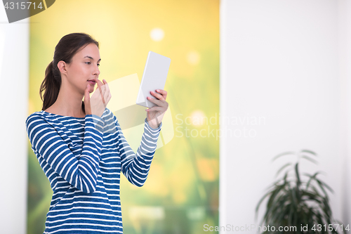 Image of young woman at home websurfing