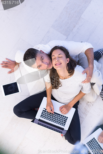 Image of couple using tablet and laptop computers top view