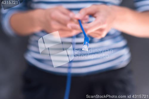 Image of woman holding a internet cable in front of chalk drawing board