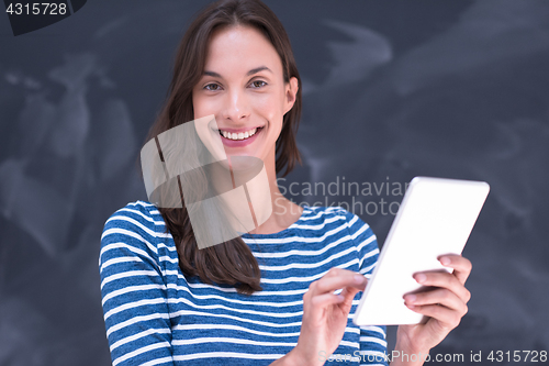 Image of woman using tablet  in front of chalk drawing board