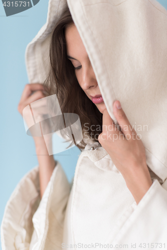 Image of woman in a white coat with hood isolated on blue background