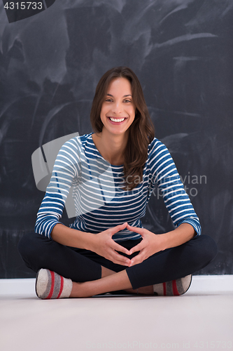 Image of woman sitting in front of chalk drawing board