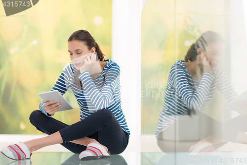 Image of young women using tablet computer on the floor