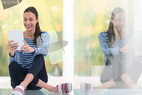 Image of young women using tablet computer on the floor