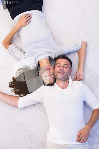 Image of handsome couple lying on floor