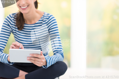 Image of young women using tablet computer on the floor