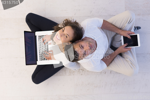 Image of couple using tablet and laptop computers top view