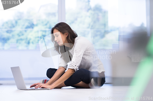 Image of young women using laptop computer on the floor