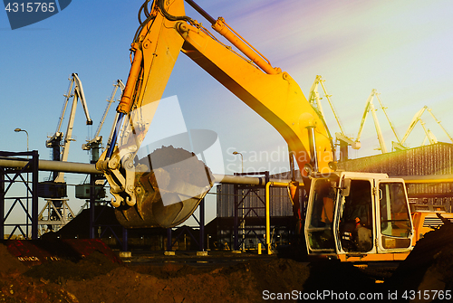 Image of Hydraulic excavator at work. Shovel bucket and cranes against bl