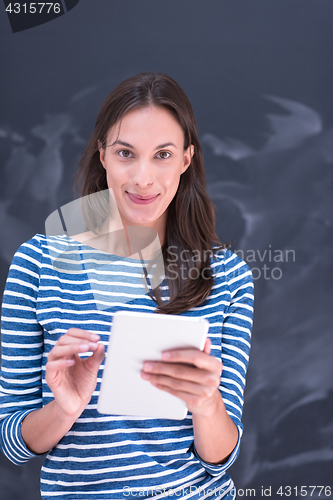 Image of woman using tablet  in front of chalk drawing board