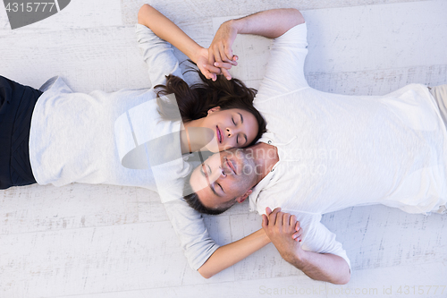 Image of handsome couple lying on floor