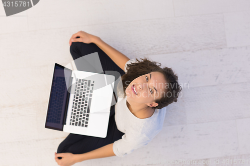 Image of women using laptop computer on the floor top view