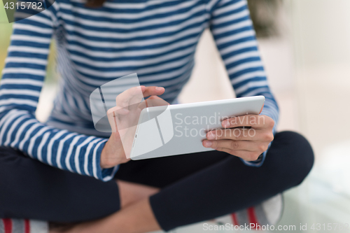 Image of young women using tablet computer on the floor